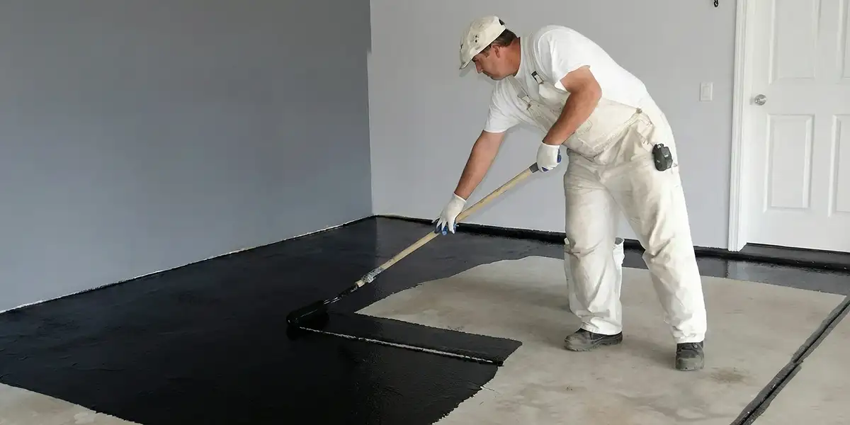 basement waterproofing professional applying waterproof coating to protect a basement floor in Boca Raton, FL