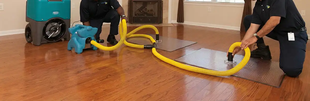 emergency water removal technicians extracting standing water from a home using professional equipment in Boca Raton, FL